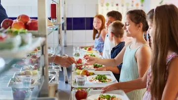 Kinder holen sich ihr Mittagessen in der Schulkantine.
