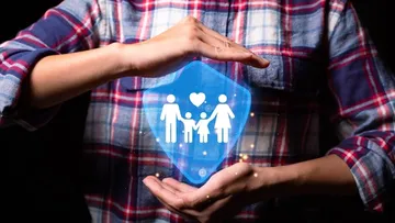 Hände umschließen ein Symbol mit einer Familie und einem Herz.